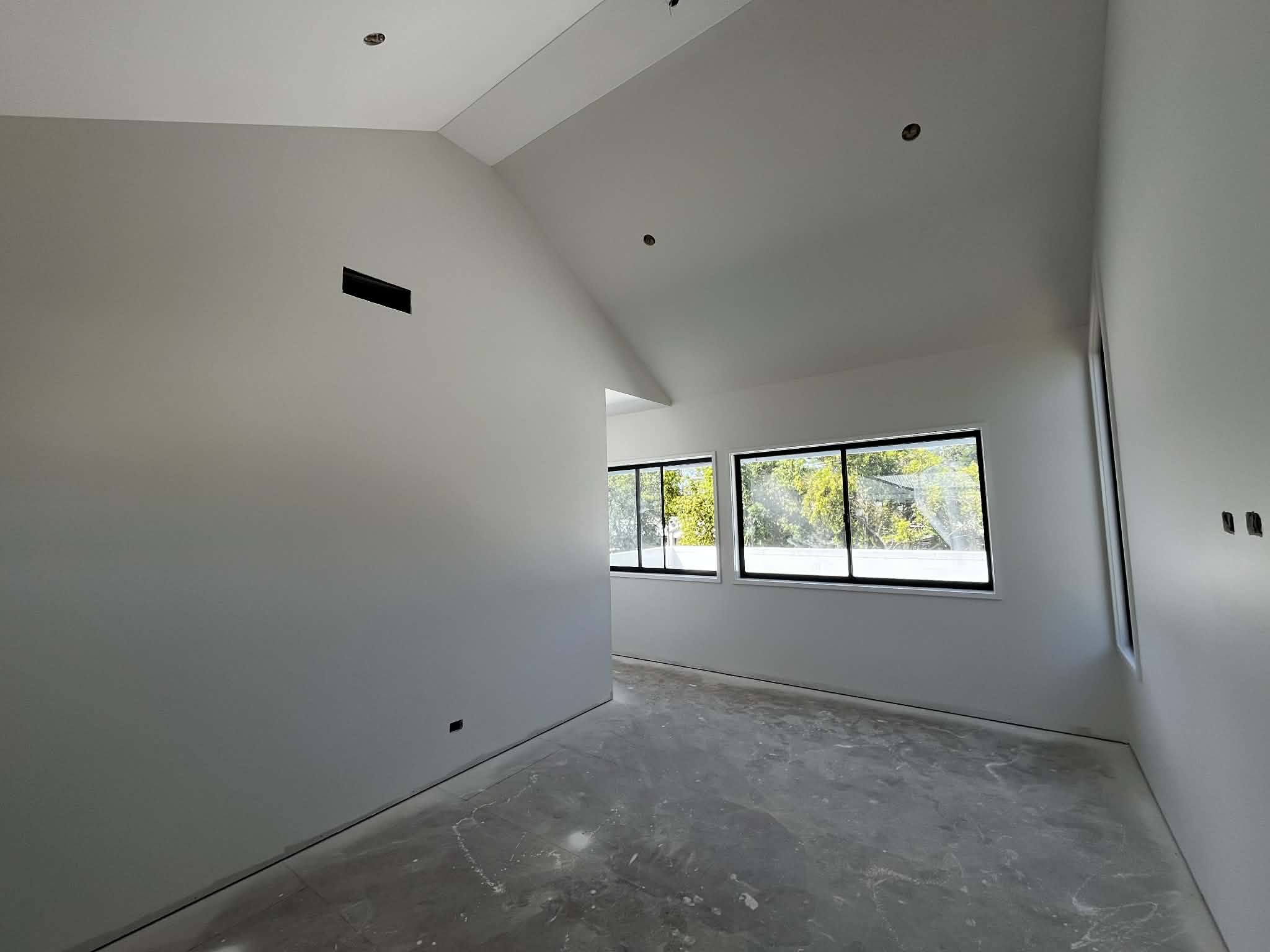 Painted vaulted room with black framed windows